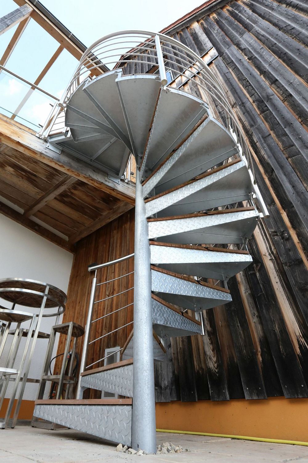 Verzinkte Stahl-Spindeltreppe mit WPC-Stufenbelag und Edelstahl-Relinggeländer