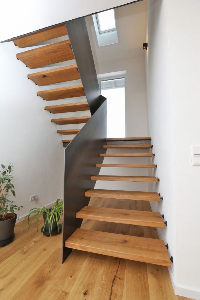 Podesttreppe als Systemtreppe mit Handlaufhoher Geländerscheibe in Rohstahl