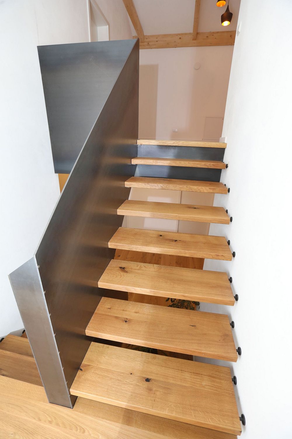 Podesttreppe als Systemtreppe mit Handlaufhoher Geländerscheibe in Rohstahl