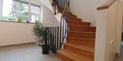 Trittstufen und Setzstufen in Eiche auf 2/4-Wendungstreppe mit Flachstahlrahmengeländer mit Handlauf in Eiche